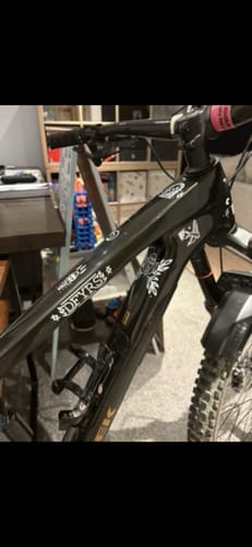A customer's black bike frame with several white Occult Transfer Decals applied along the top tube.