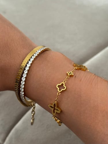 Rezensentin trägt das goldene Prestige Clover Armband mit Kleeblatt-Anhängern an ihrem Handgelenk.