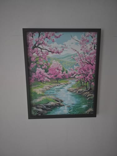 Customer's completed Blossom River Trail paint by numbers, framed and displayed on a wall.