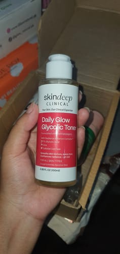 Reviewer holding their bottle of Daily Glow Glycolic Toner over an open box.