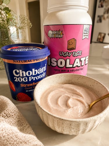 Customer's UGLYFACE® ISOLATE PROTEIN tub next to a bowl of creamy pink protein yogurt.