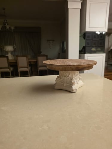 Customer's Lawrence Cake Stand with its fir wood top and antique white pedestal, shown on a kitchen counter.