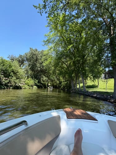 Customer's view from a boat on a sunny lake, the setting for using their Universal Buddy can cooler.