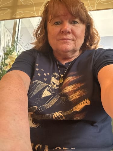 Reviewer wearing the dark blue American Rock 250 T-Shirt featuring a graphic of Lincoln playing a guitar.