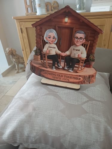 Reviewer's personalized wooden cabin plaque with a couple in rocking chairs inscribed 'Growing Old Together Since 1976'.