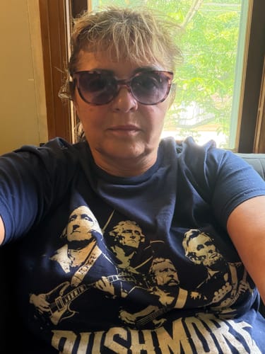 Reviewer wearing the dark blue Rushmore Tour 250 T-Shirt showing the graphic of presidents as a rock band.