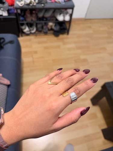 Una cliente mostrando el Anillo Ajustable Soho en su dedo, de diseño plateado y dorado.