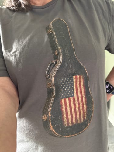 Customer wearing the gray My Dad T-Shirt with a graphic of a guitar case and American flag.