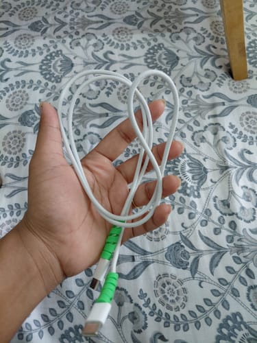 Customer holding a white cable with two green Cable Protectors reinforcing the connector ends.