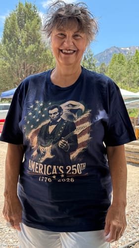 Customer smiling while wearing the graphic Lincoln Eagle 250 T-Shirt outdoors.
