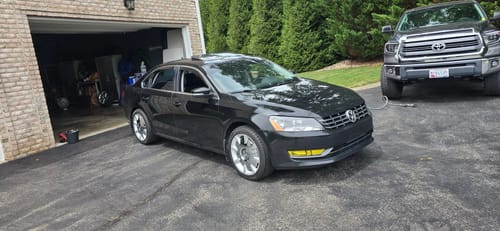 Customer's black Volkswagen sedan parked in a driveway with wheel spacers installed, giving it a wider stance.
