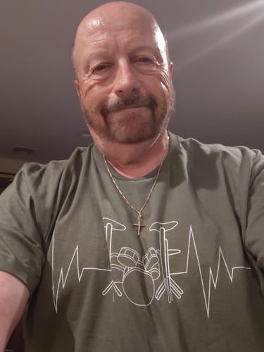 Customer wearing the olive green Drummer Heartbeat T-Shirt with a white graphic.