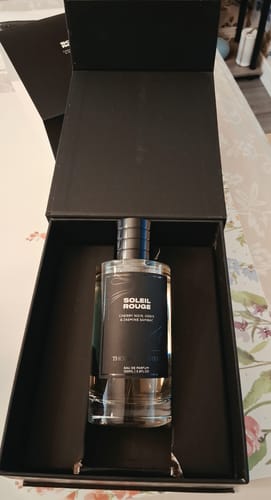 Customer's Soleil Rouge Eau de Parfum bottle nestled inside its open, elegant black presentation box.