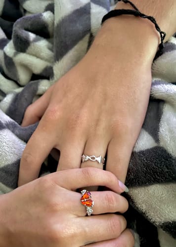 A reviewer's hand wearing the silver Barbed Wire Ring, resting on another person's hand.