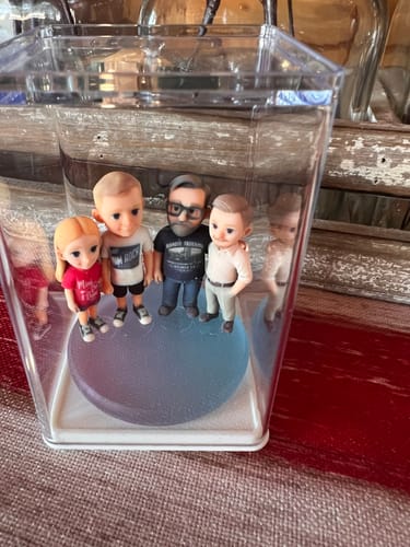 Customer's DoDoWish Personalized 3D Figurine set of a family of four, inside its clear display case.