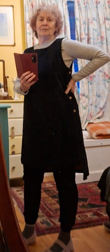 Customer showing the fit of the long black corduroy vest, layered over a grey shirt and black leggings.