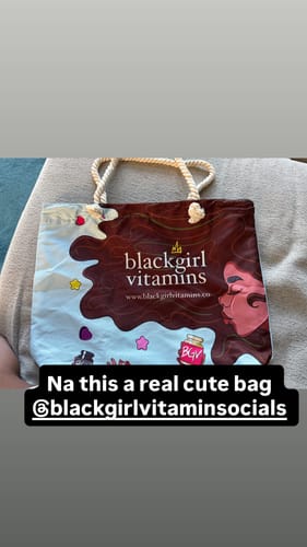 Customer showing the colorful promotional tote bag they received as a gift with their purchase.
