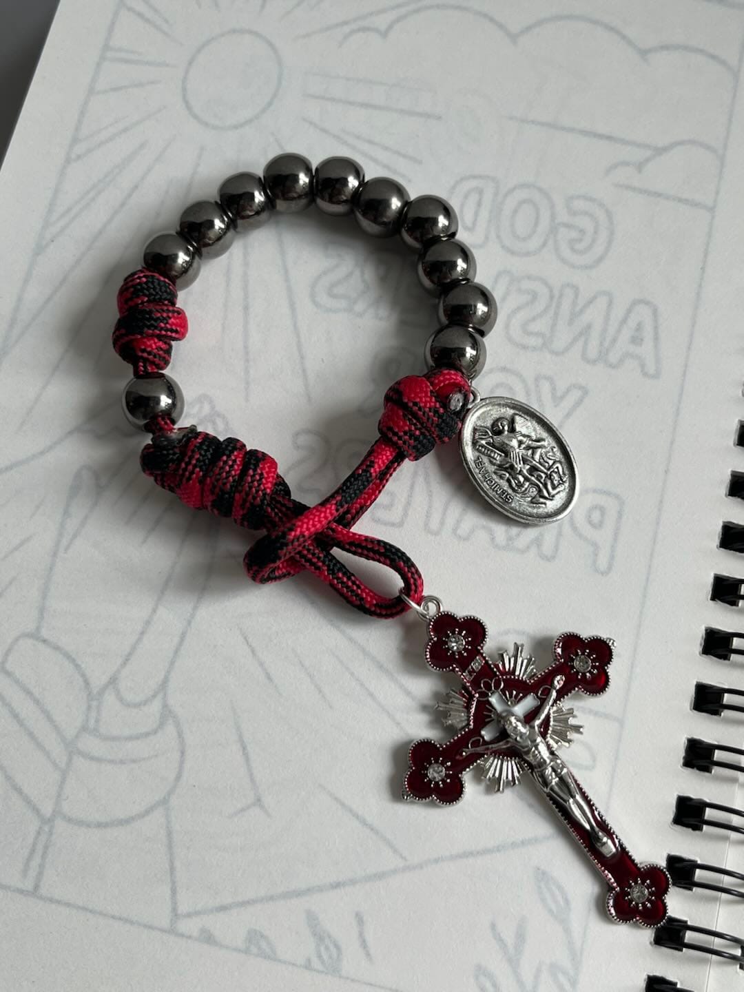 Customer photo review of Solacebeads Gunmetal Bead Car Rosary & Red Enamel Crucifix: Rooted In St. Michael Protection