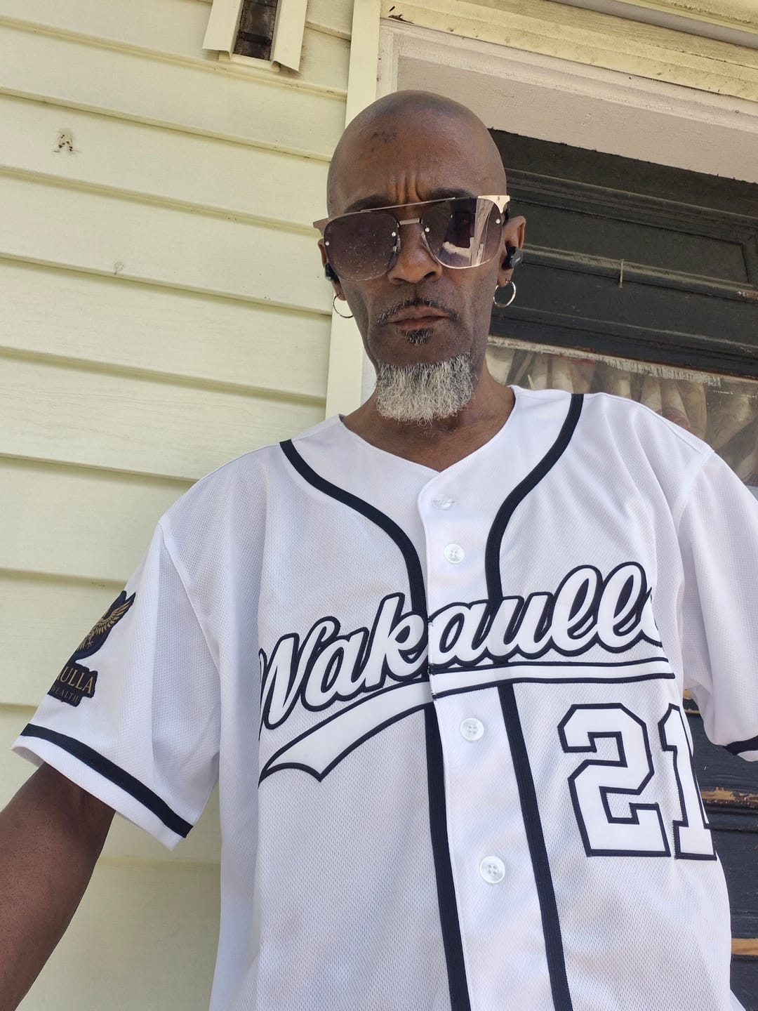 Customer wearing a custom white baseball jersey with black trim, the name 'Vakaull' and the number '21' on the front.