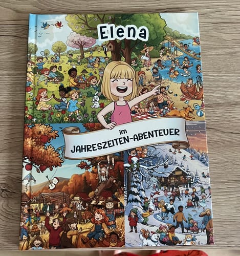 Kunde zeigt das personalisierte Wimmelbuch 'Jahreszeiten' mit dem Namen 'Elena' auf dem farbenfrohen Cover.