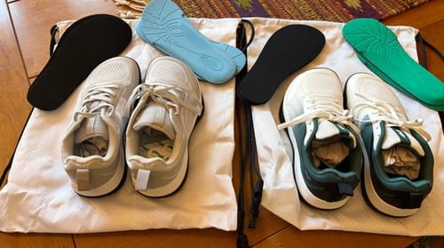 Customer's two pairs of CUURT Muuv court shoes in white and green, displayed with various insoles.
