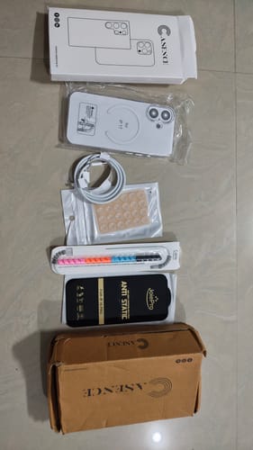Customer's unboxed Anti Yellow Magsafe Clear Case displayed on the floor with its packaging and various accessories.
