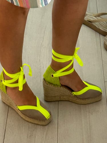 Cliente usando las alpargatas Mara Amarillo, mostrando el perfil con las cintas amarillas atadas al tobillo.