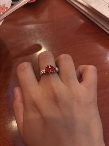 Customer's hand showing the MINI PROMISE RING with its two red, coffin-shaped stones on a detailed band.