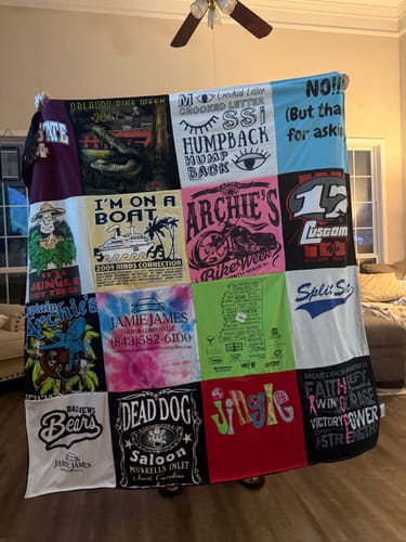 Customer's colorful Project Repat T-Shirt Quilt held up indoors, featuring many memorable t-shirt squares.