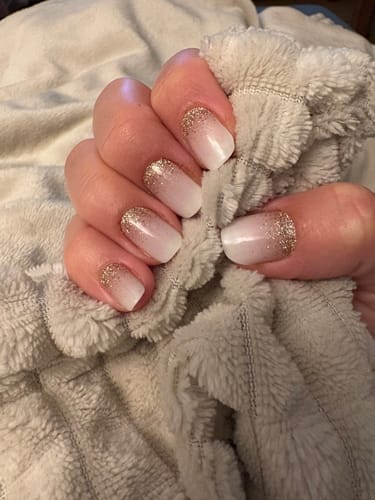 Hand einer Kundin mit aufgetragenen 'Babyboomer Nude Sparkle' UV-Gelfolien, die einen Ombré-Effekt und Glitzerpartikel zeigen.