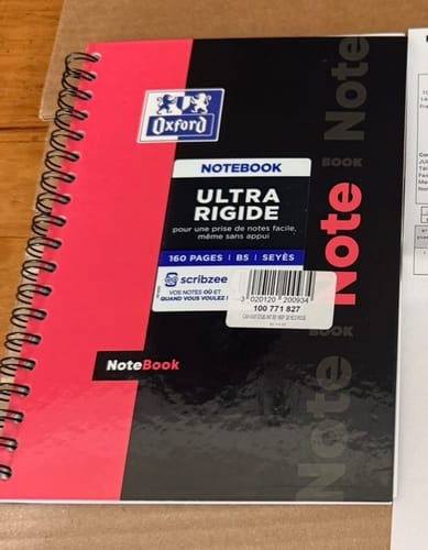 Client montrant le cahier Oxford NOTEBOOK ULTRA RIGIDE rose et noir reçu par erreur à la place de l'Organiserbook.