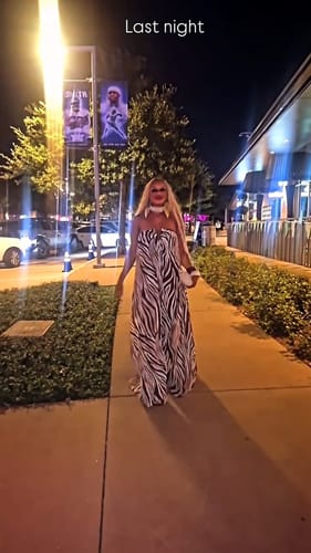 Reviewer walking on a sidewalk at night in the full-length, flowy Chiffon Print Wide-Leg Jumpsuit.