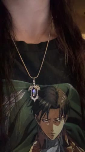 Close-up of a reviewer wearing the silver Birthstone Pendant with a dark oval stone on a thin chain.