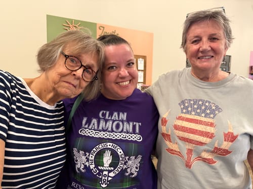 Reviewer wearing the Vintage Flag Thistle T-Shirt while posing with two other people.