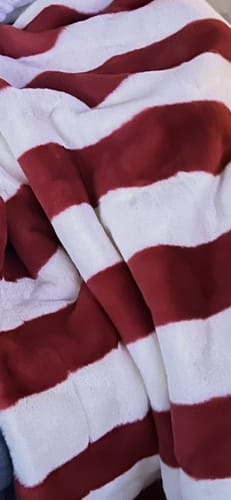 Close-up of a customer's soft, plush Lush Flag Blanket showing the red and white striped material.