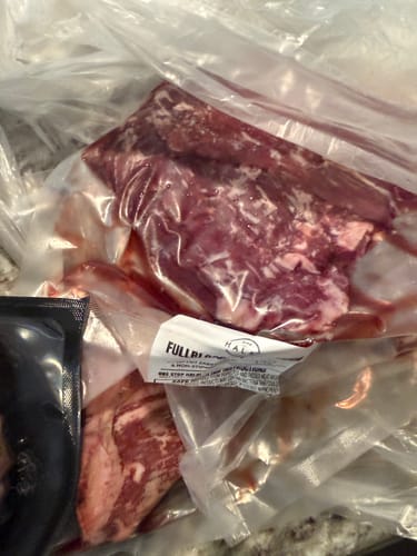 Customer's close-up of the spoiled vacuum-sealed meat from the damaged shipment.