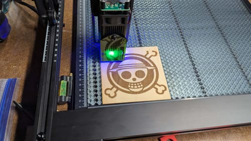 Customer's AtomStack A5 laser engraver in action, etching a skull logo design onto a piece of wood.