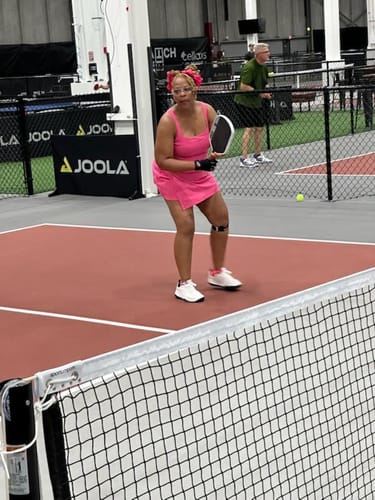 Reviewer on a pickleball court wearing white CUURT Muuv court shoes during a game.