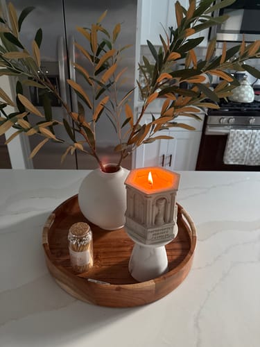 Customer's lit The Monument — Coco Santal candle on a decorative wooden tray in a kitchen.