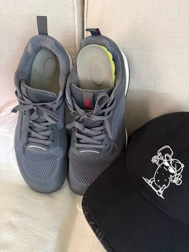 Reviewer's grey CUURT Muuv court shoes, with one shoe showing the extra cushioned insole they added.