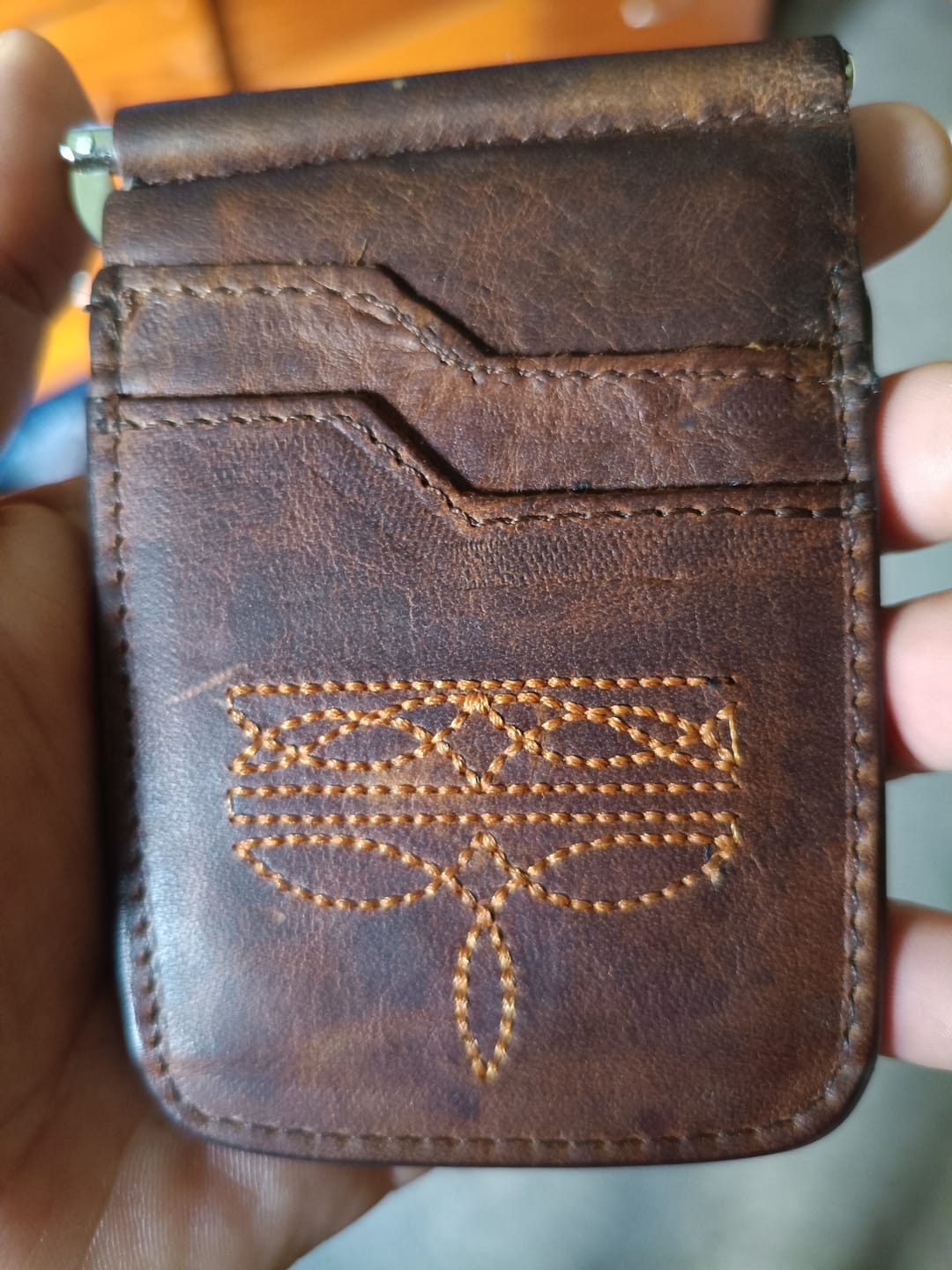 Customer photo review of Billetera de clip César – Piel café cerro con ringle bordado naranja.