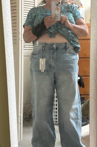 Reviewer in a mirror selfie showing the fit of the high-waist, baggy Judy Blue jeans.