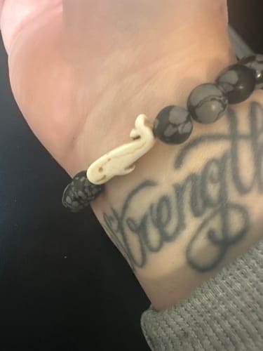 Customer wearing The Wayfare Bracelet with patterned grey beads and a whale charm on their wrist.