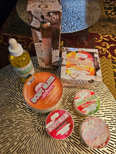 Customer's Scent from Heaven Body Drops bottle arranged with a collection of Body Glaze products on a table.
