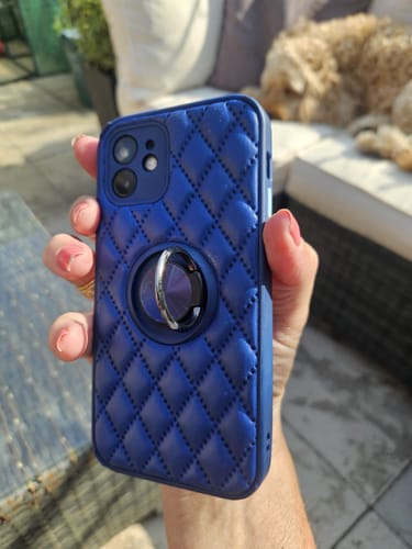 Customer holding their dark blue diamond quilted phone case with the ring holder on the back.