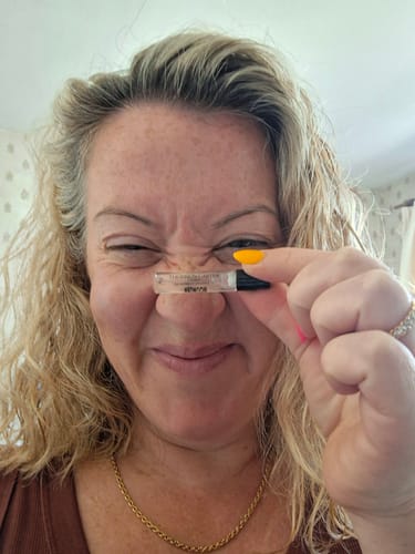 Reviewer playfully holds a small sample vial from the Fragrance Discovery Kit up to her nose.