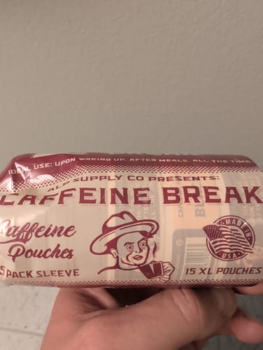 Customer's hand holding a 5-pack sleeve of Caffeine Break Caffeine Pouches, showing the front packaging.