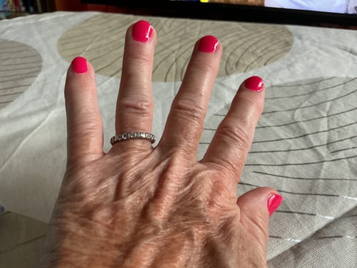 Hand einer Kundin mit leuchtend pinken Nägeln nach der Anwendung des Colour Flash Maniküre Sets.