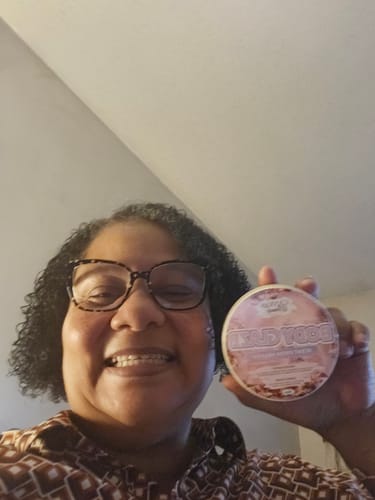 Customer smiling while holding her BODY GLAZE: SCENT FROM HEAVEN.
