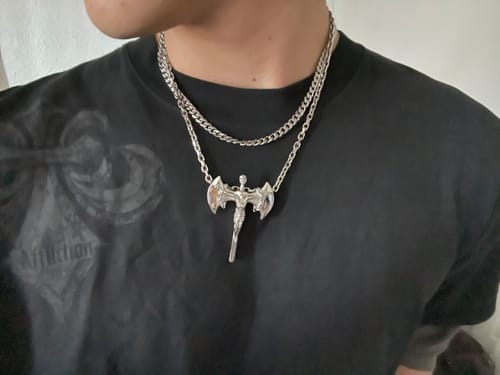 Customer wearing the silver Aries Chain layered with another chain and a large pendant over a black t-shirt.